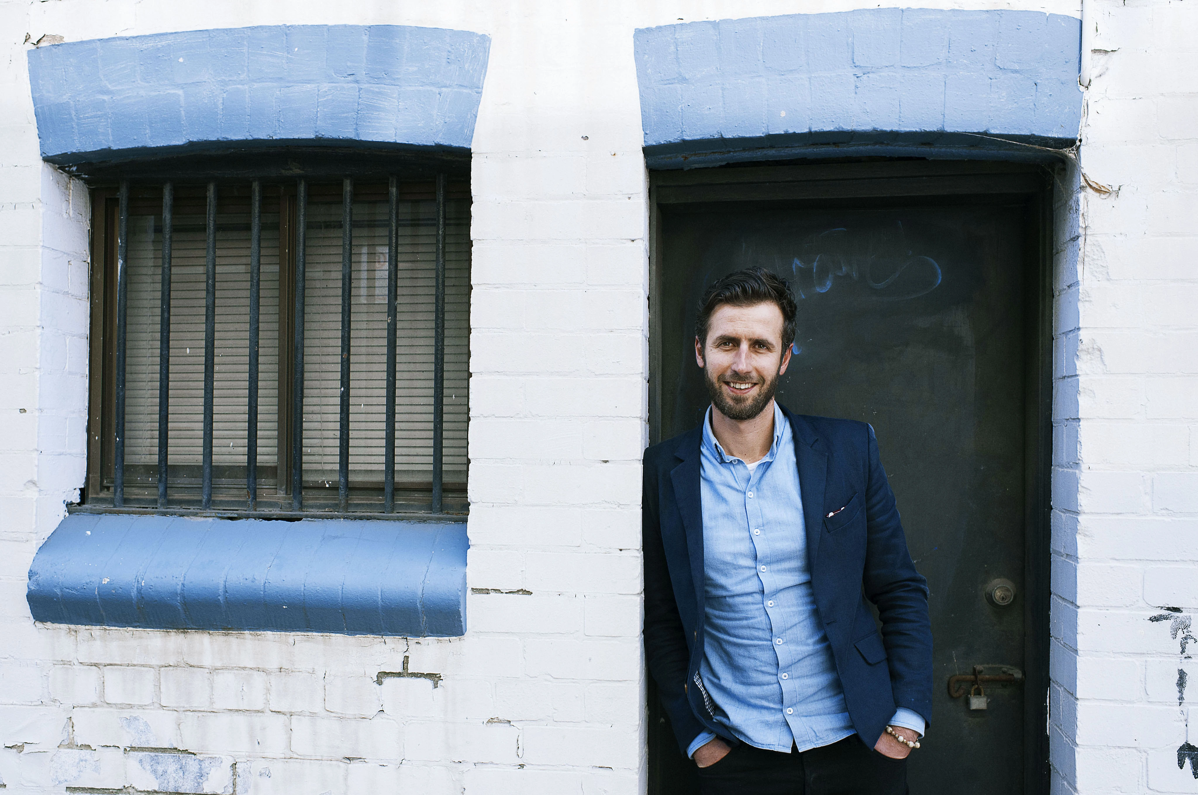 Stevan Premutico standing in a doorway in a blue blazer and shirt.