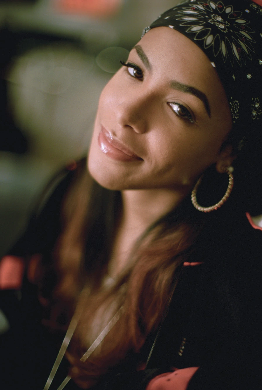 Portrait of Aaliyah (Aaliyah Keef) wearing a patterned headscarf and hoop earrings, close-up editorial-style photo