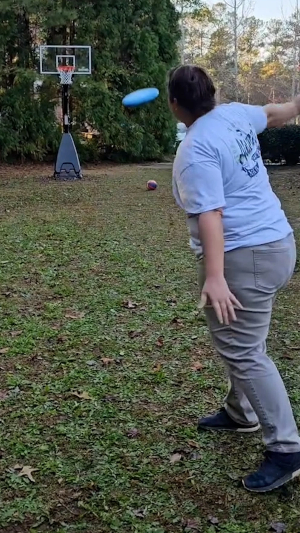 Amanda Badertscher preparing a trick shot outdoors on a grassy lawn.