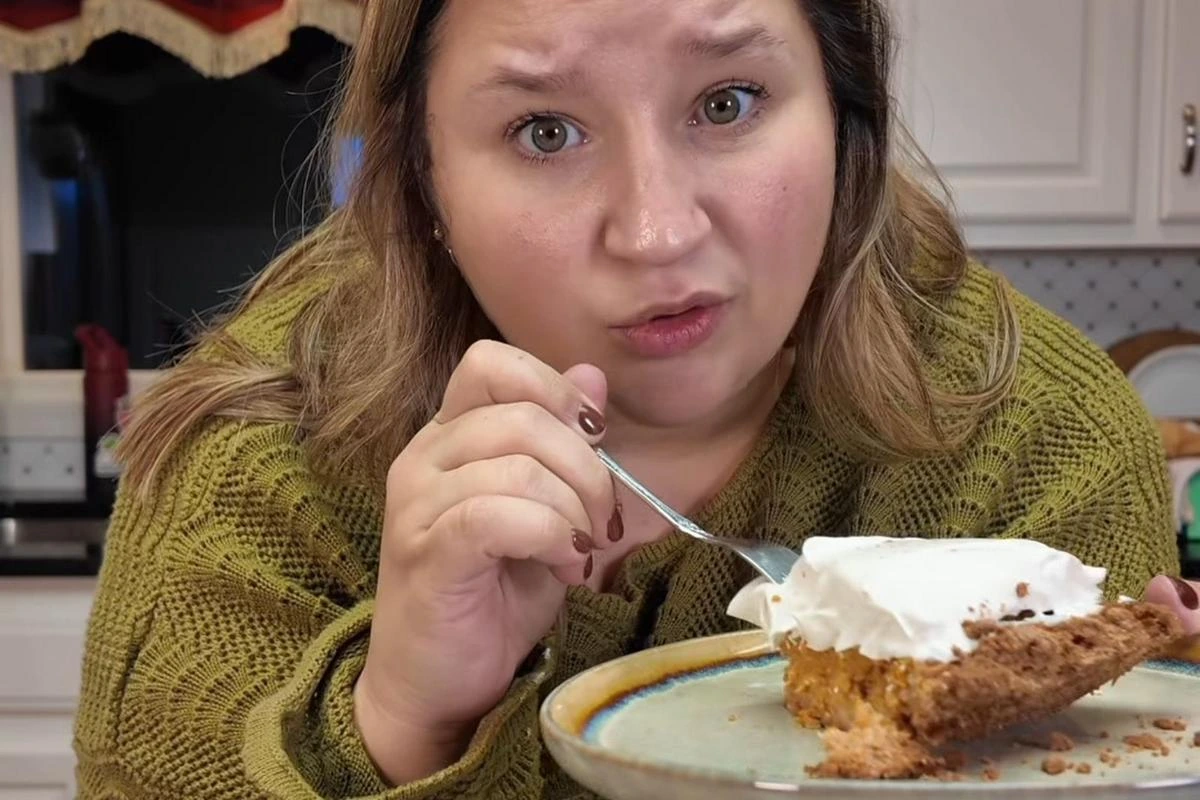 Jessica Secrest holding a slice of dessert in a kitchen