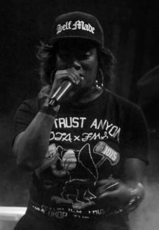 Gangsta Boo performing on stage holding a microphone