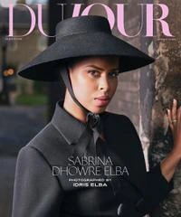 Sabrina Dhowre Elba on the cover of a fashion magazine, wearing a black hat and dark coat.