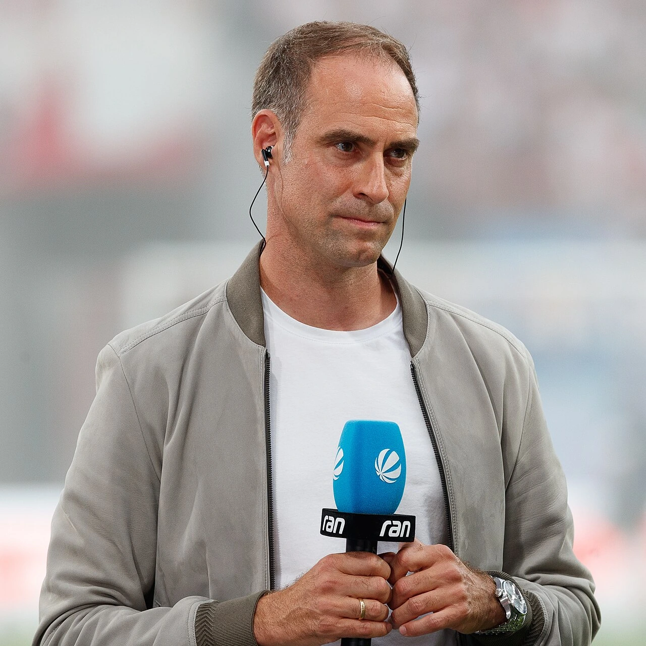 Oliver Mintzlaff holding a microphone at a football event