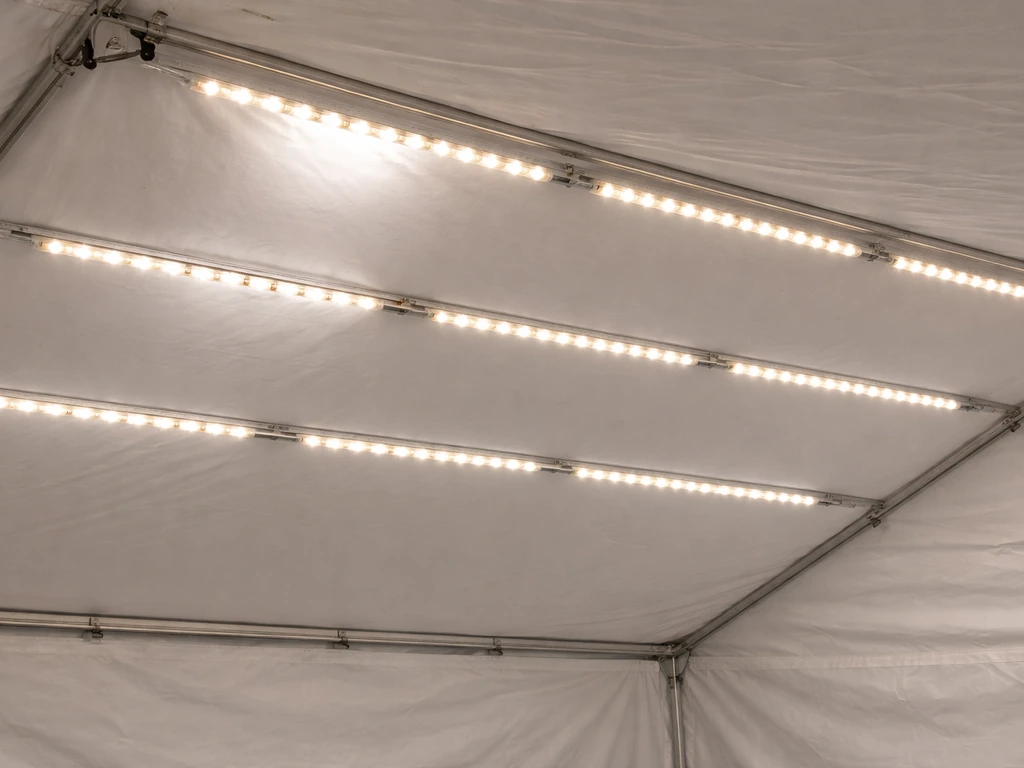 Angled view of evenly spaced LED strips on a canopy, showing hotspot vs uniform light coverage.