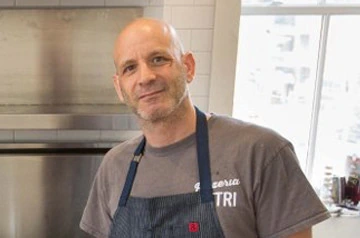 Marc Vetri, Philadelphia chef and restaurateur, standing in a kitchen wearing an apron