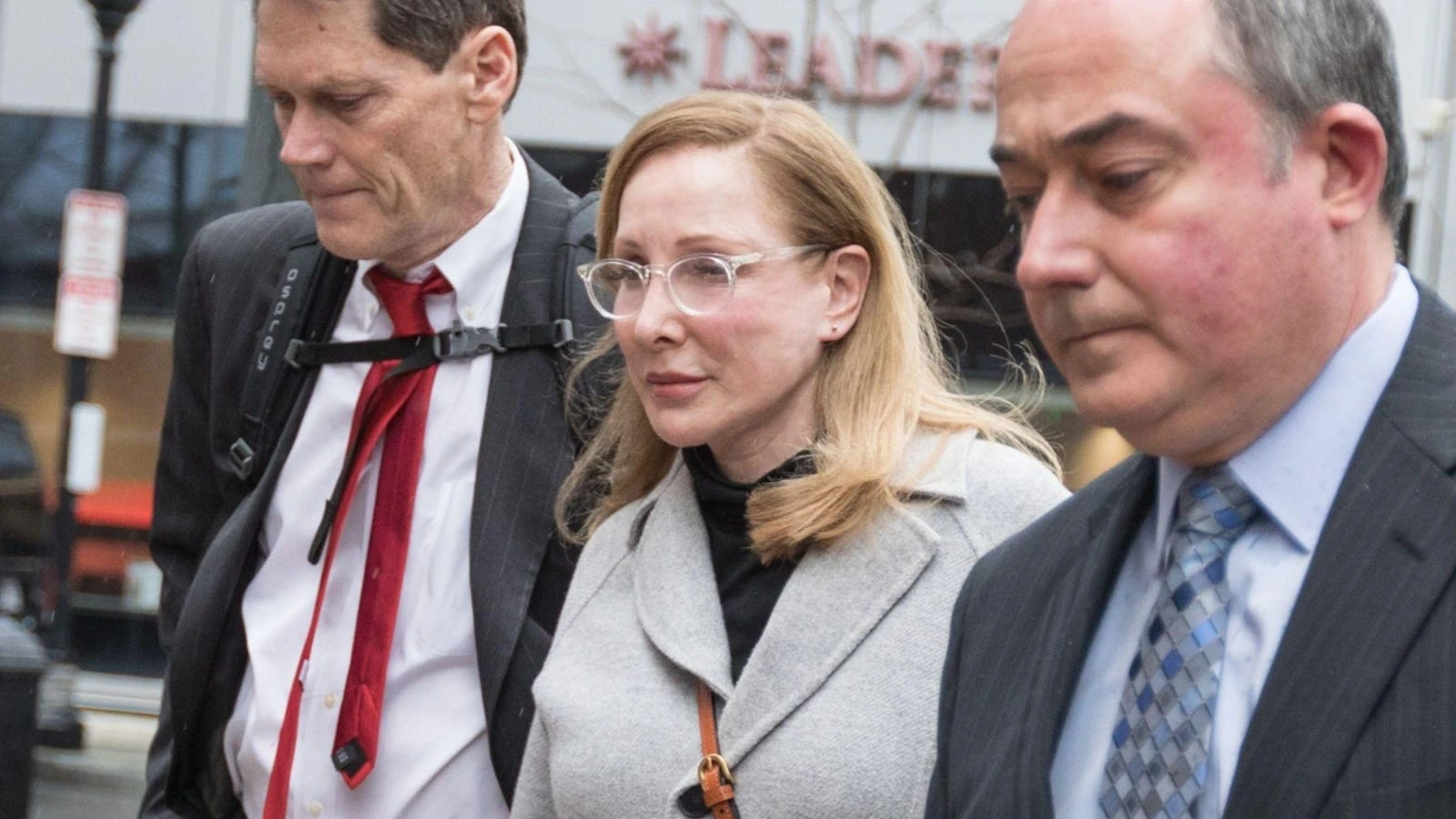 A candid news photo of Marci Palatella walking with two men outdoors.