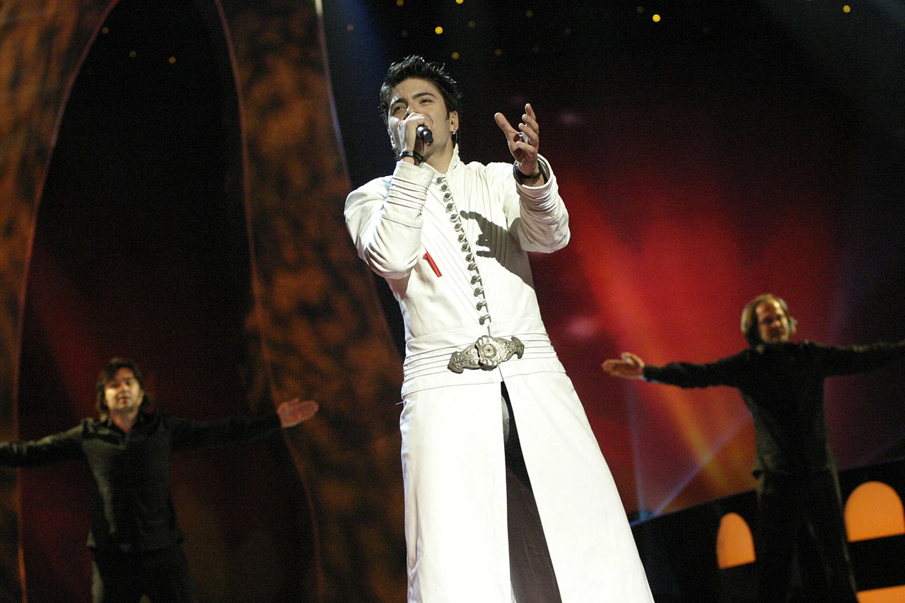 Toše Proeski performing on stage with arms outstretched, singing into a microphone