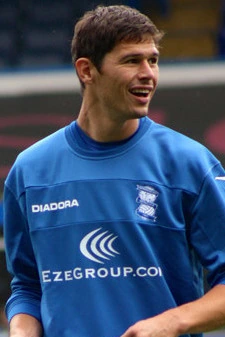 Nikola Žigić in a blue football training top, smiling on the pitch