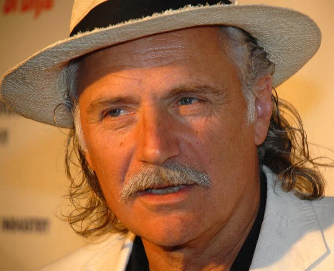 Portrait of Rade Šerbedžija wearing a light-colored hat and jacket