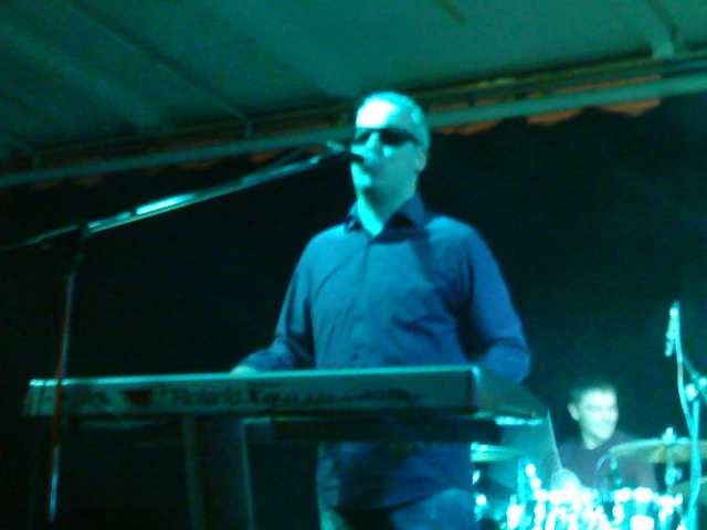 Saša Matić performing on stage at a keyboard microphone setup