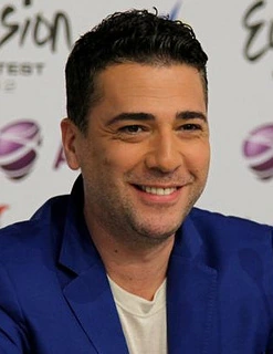 Željko Joksimović smiling at an event, wearing a blue jacket