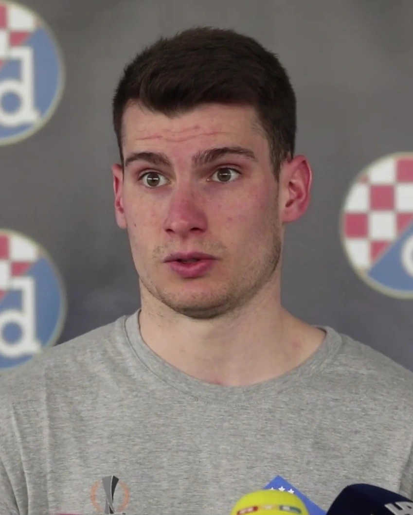 Portrait of Dominik Livaković, Croatian professional goalkeeper, in front of a Croatia backdrop.