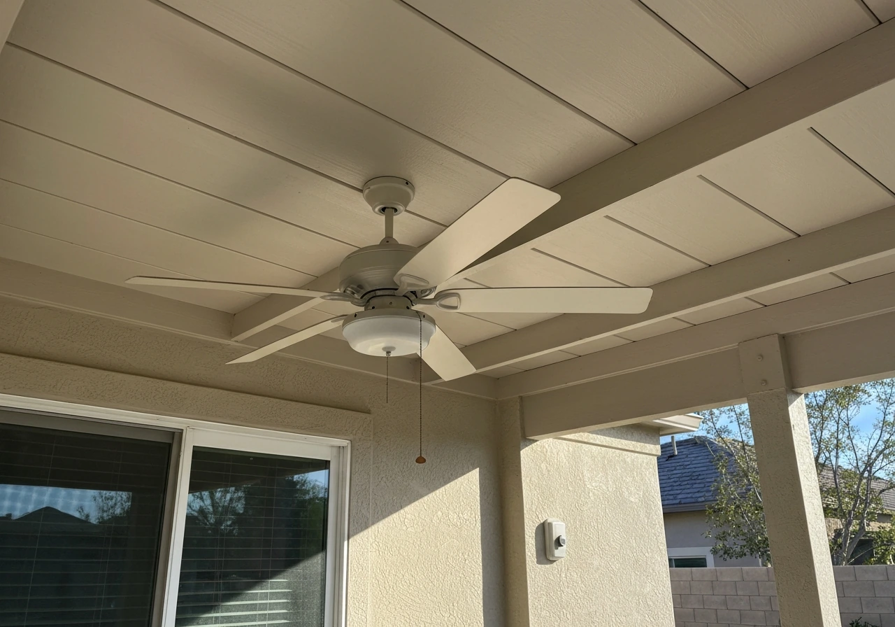 Wet-rated outdoor ceiling fan with large blades under a covered patio; wall switch visible.