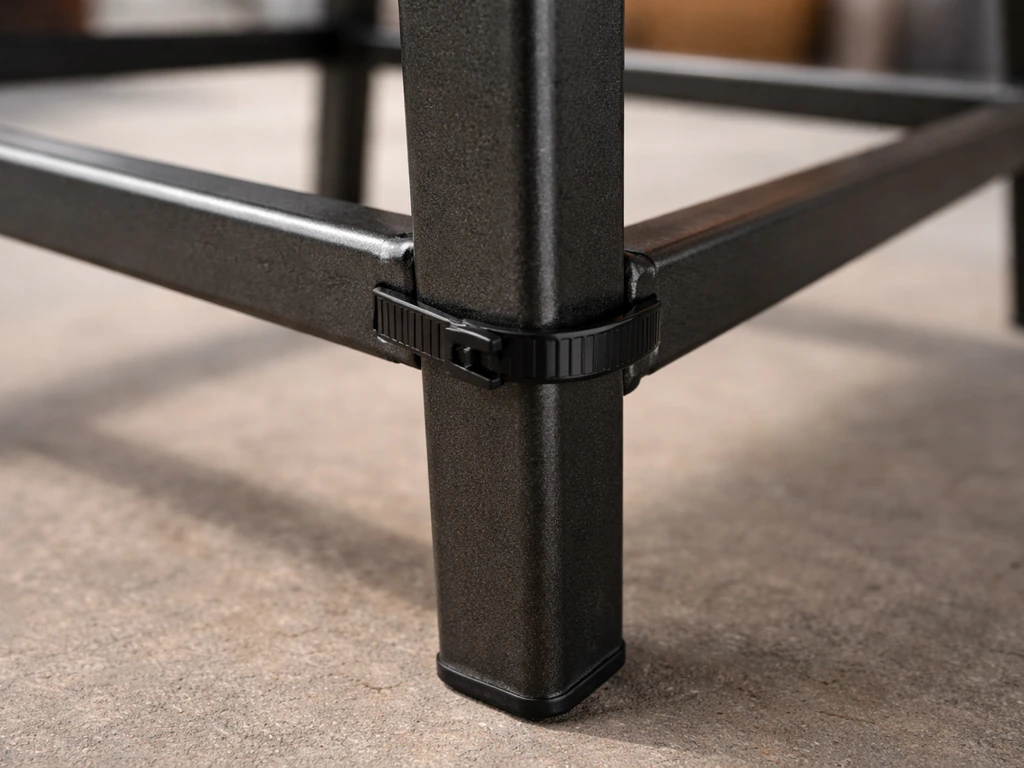 Close-up of a metal chair leg with a cable tie attached near the bottom rail, showing a solid anchor point