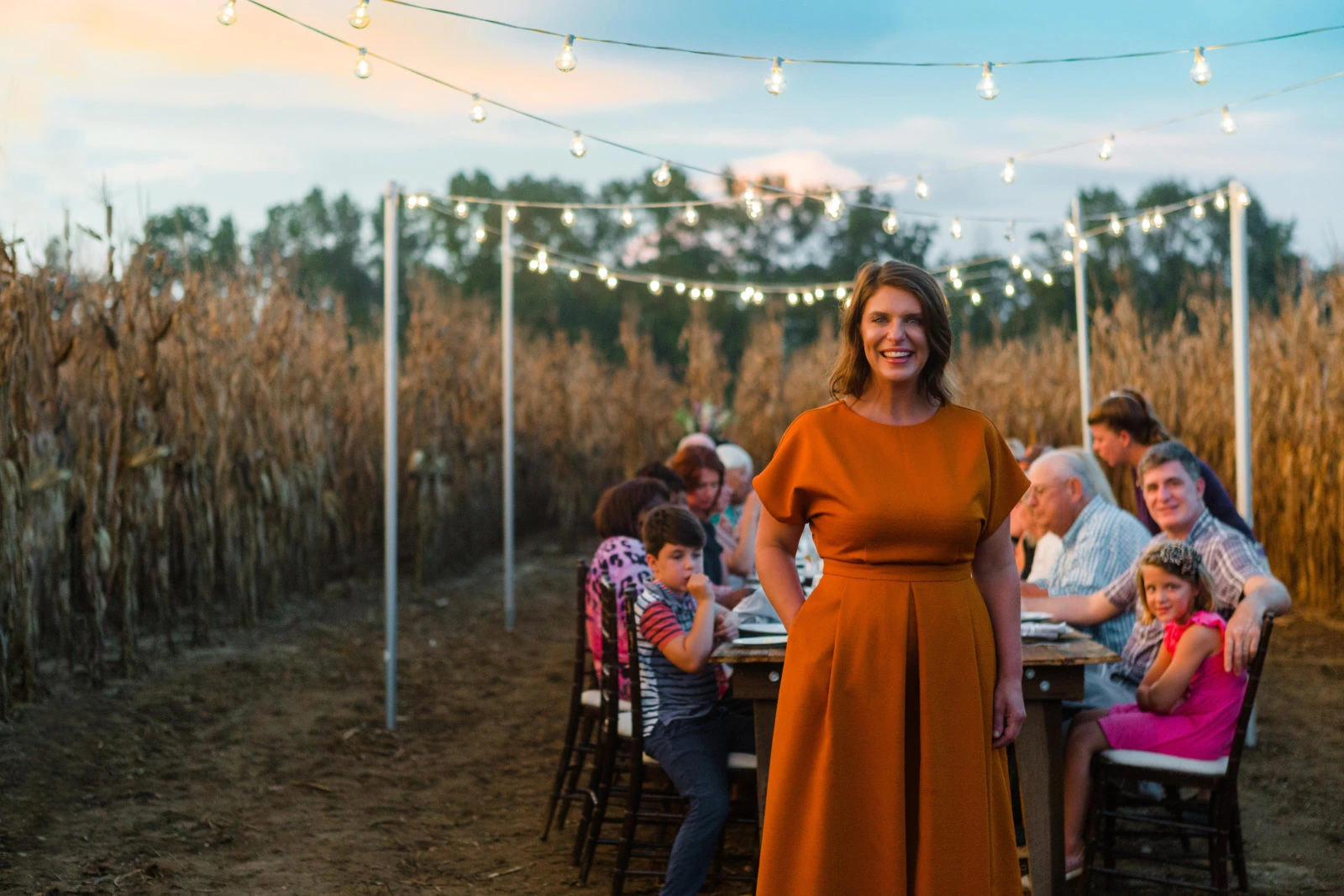 Vivian Howard standing outdoors at a long table during an evening gathering