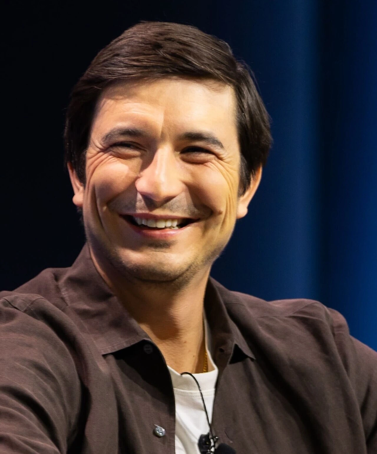 Portrait photo of Vlad Tenev, Robinhood co-founder, smiling in a close-up editorial-style image.