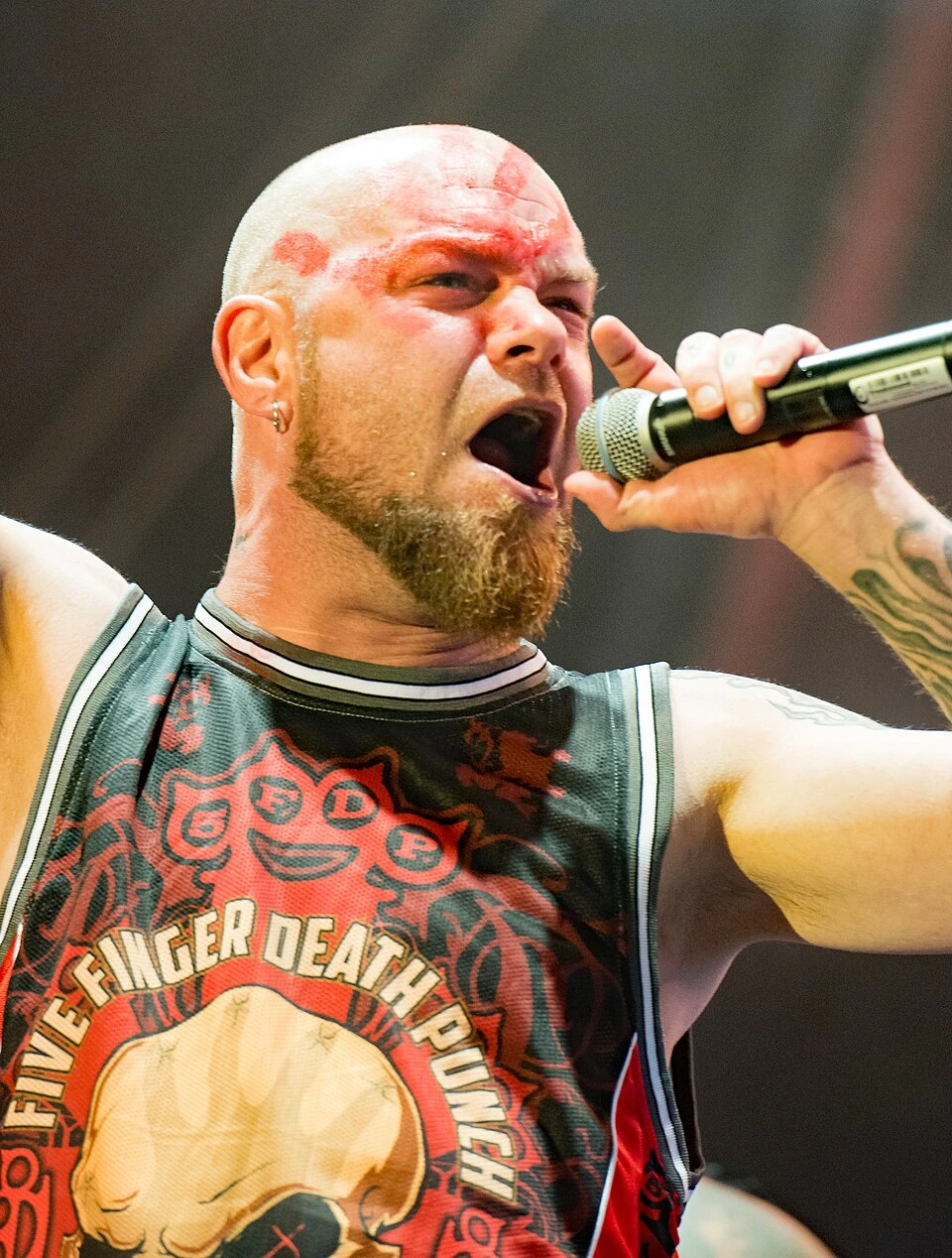 Ivan Moody singing into a microphone during a live Five Finger Death Punch performance
