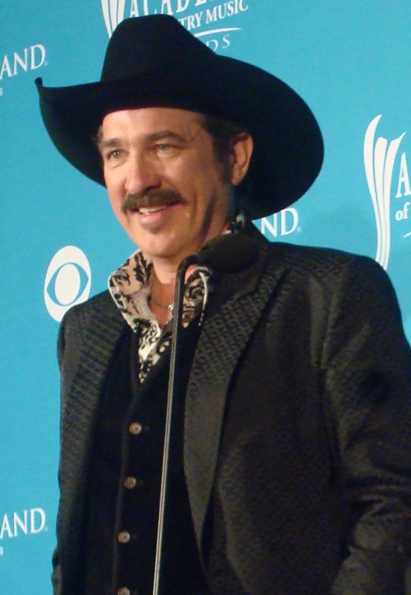 Kix Brooks speaking at an event, wearing a black cowboy hat and jacket