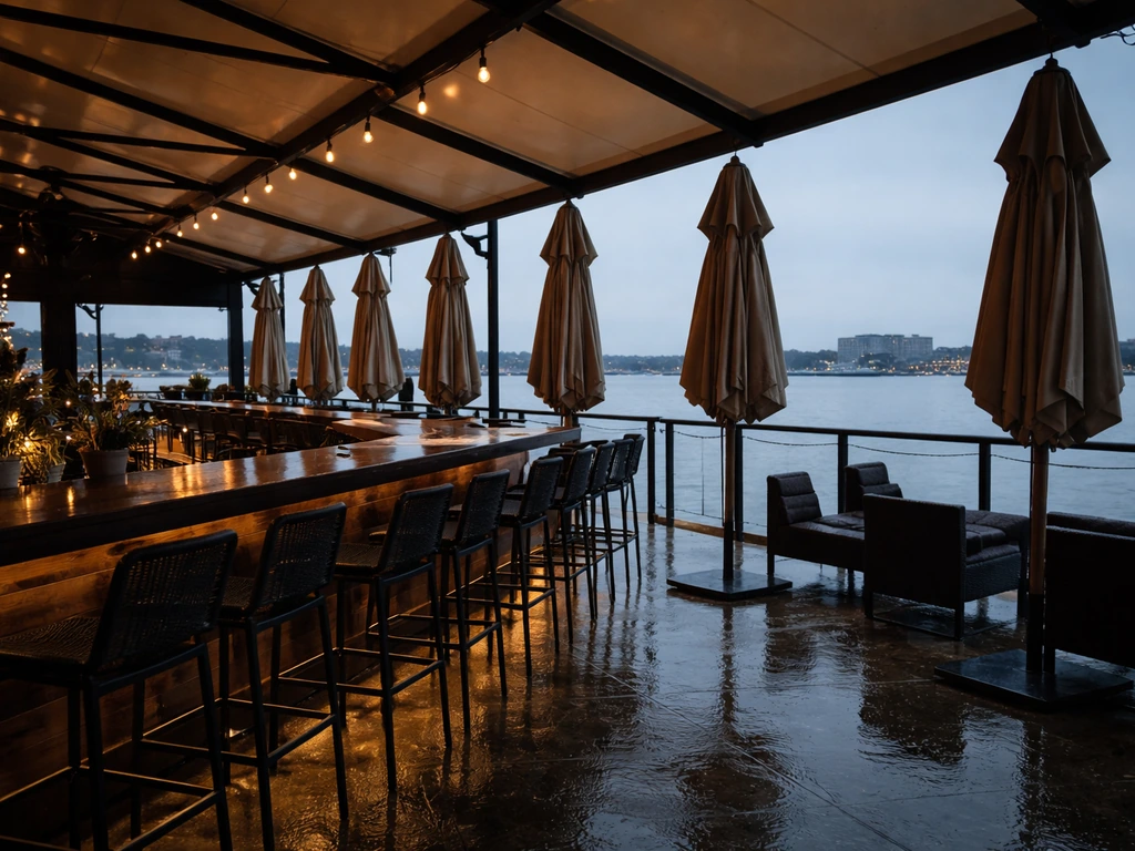 Covered waterfront patio bar setup with umbrellas and canopies overlooking calm water.
