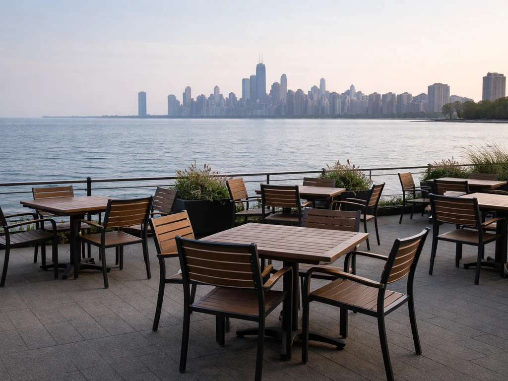 Lake Michigan-facing Waterfront Café patio with empty tables and distant Chicago skyline.