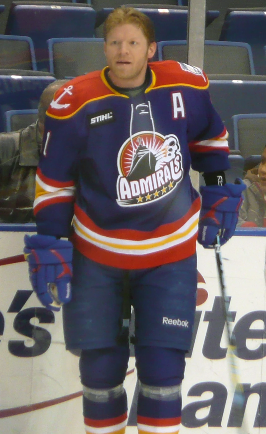 Mark Parrish in a hockey uniform standing on the ice rink, wearing an Admirals jersey.