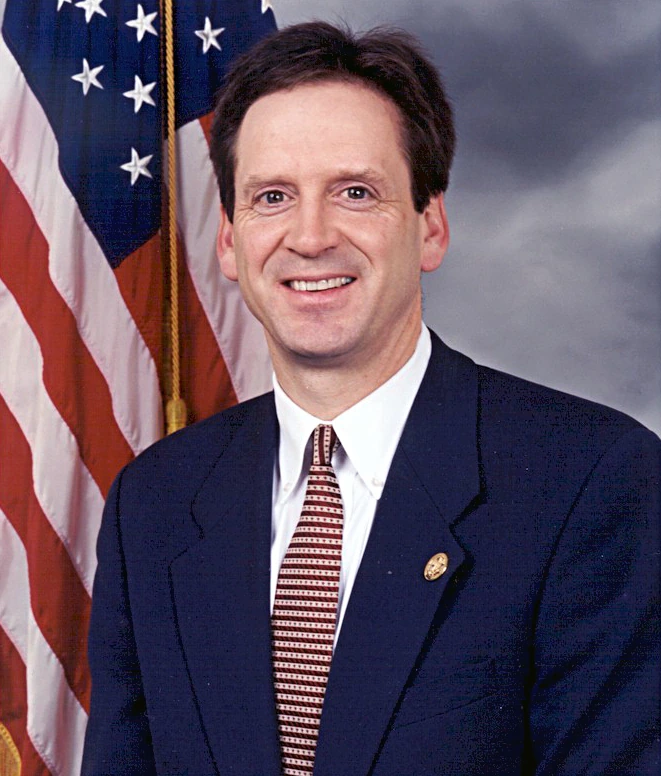 Portrait of Mark Green in a suit with an American flag backdrop