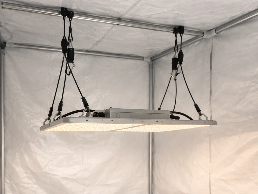 Lighthouse 2.0 grow light hanging inside a grow tent with adjustable risers and rope ratchet hangers.