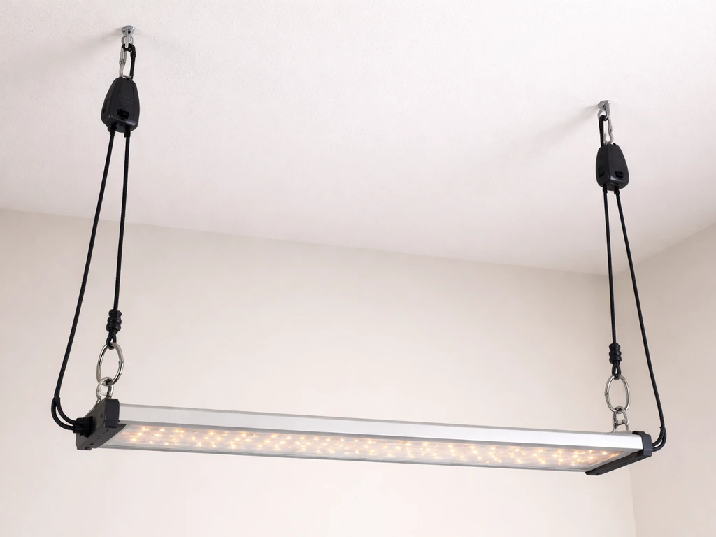 LED grow light bar suspended and leveled with ratchet rope hangers at both ends.