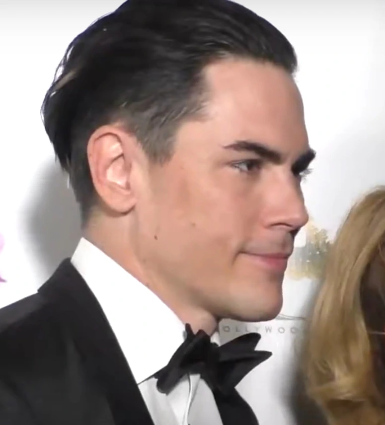 Tom Sandoval at a red carpet event, shown in profile wearing a tuxedo.