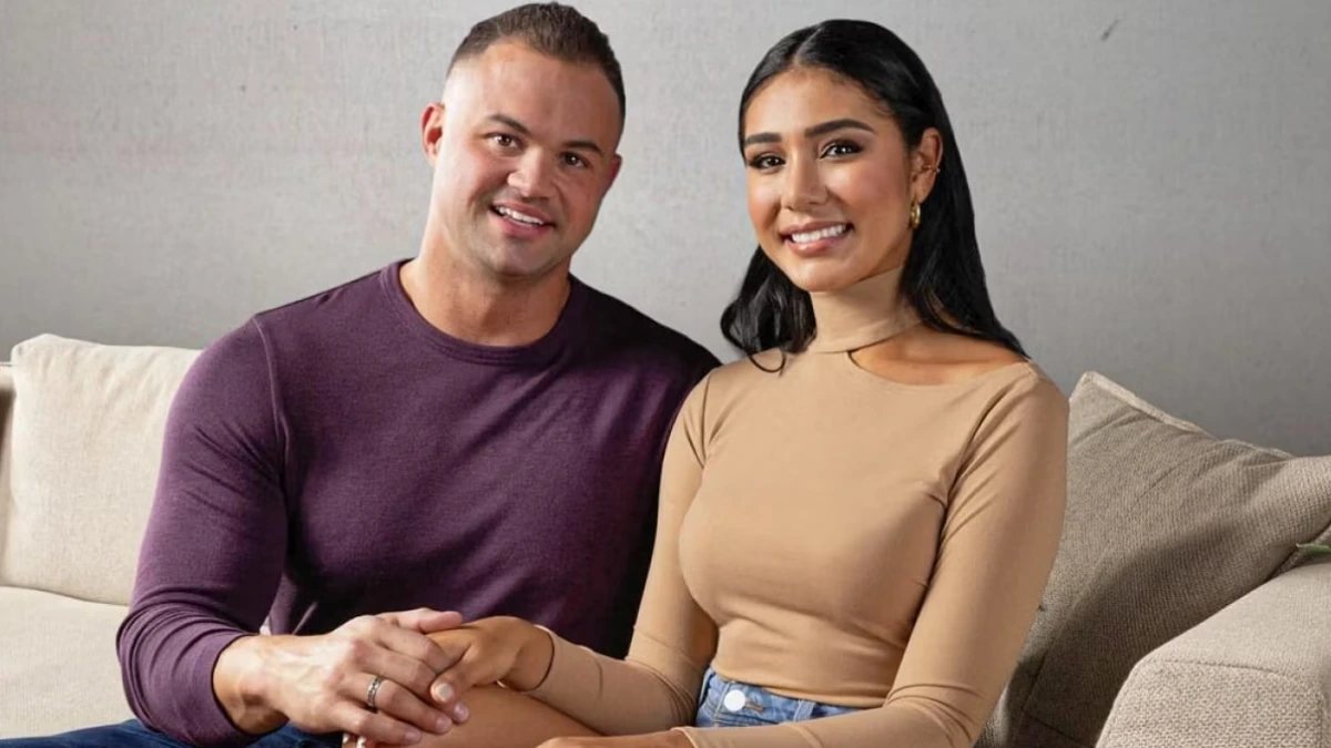 Patrick Mendes sitting beside Thais Ramone on a couch in a posed promotional photo.