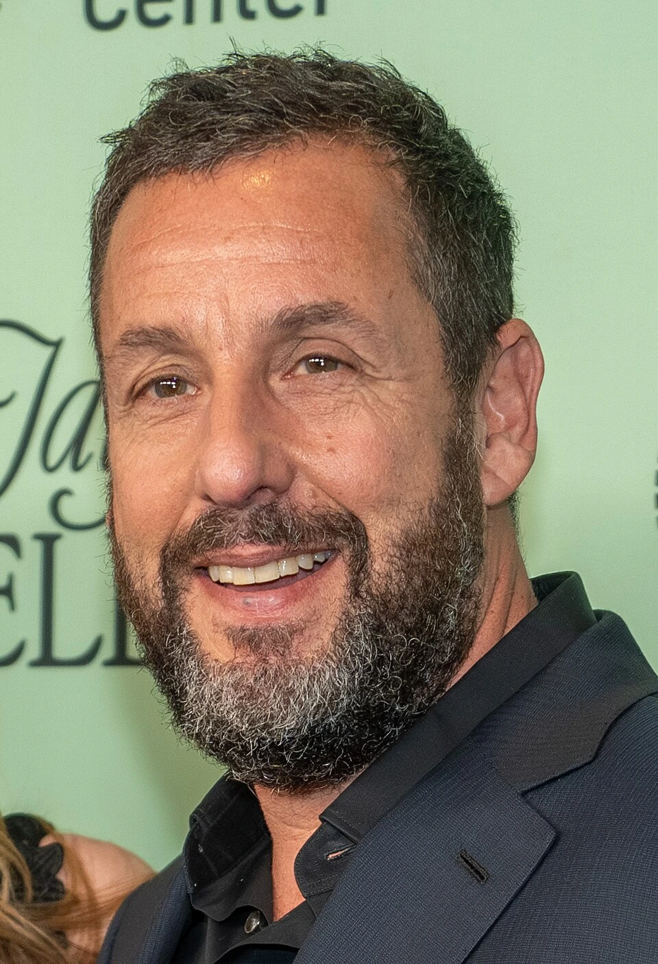 Adam Sandler smiling at an event