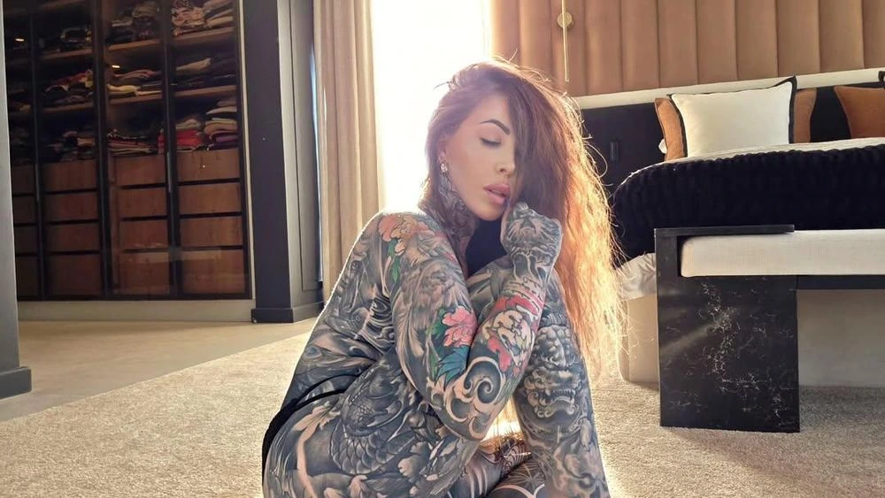 JoJo Robinson seated indoors with visible tattoos in a candid portrait-style photo