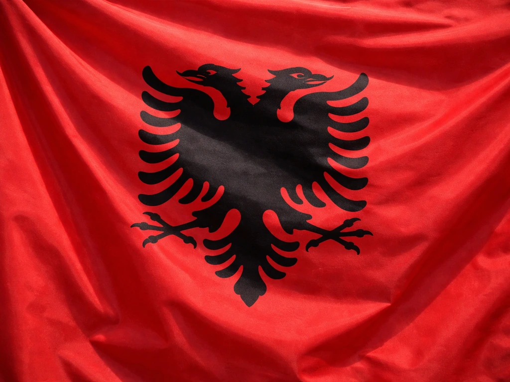 Albanian flag-inspired red cloth with a black double-headed eagle emblem motif in soft natural light.
