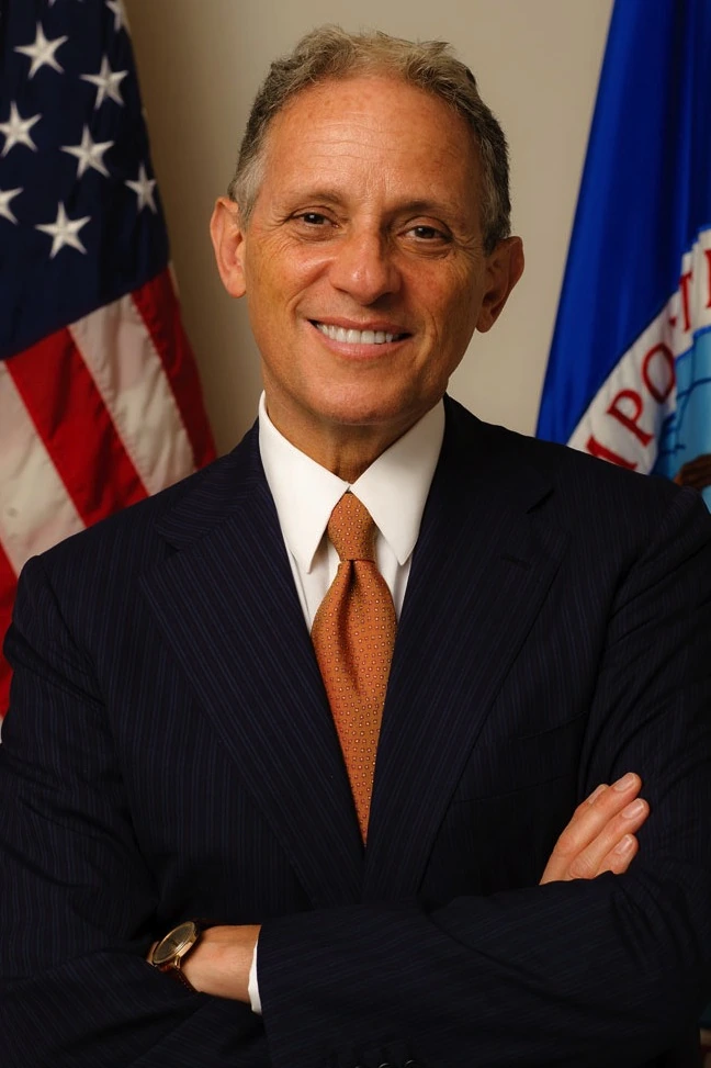 Fred P. Hochberg in a formal portrait with U.S. and EXIM flags in the background.