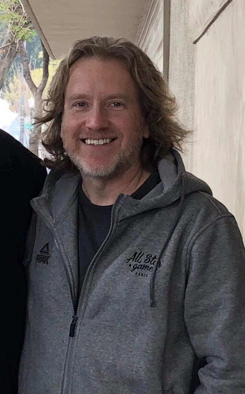 Portrait of Dieter Ruehle smiling in a gray hoodie