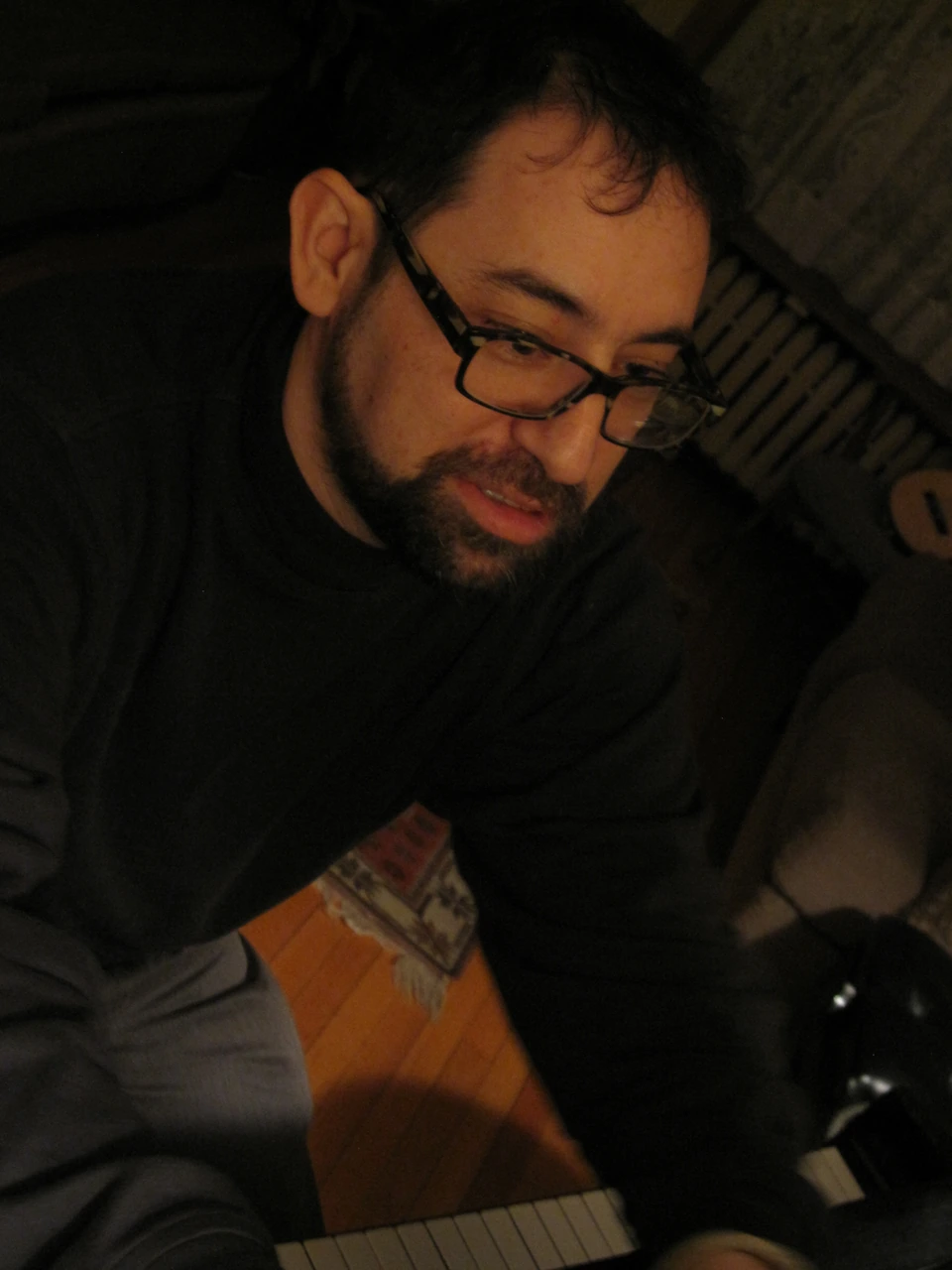 Rick Perlstein seated at a piano selecting music, March 2013