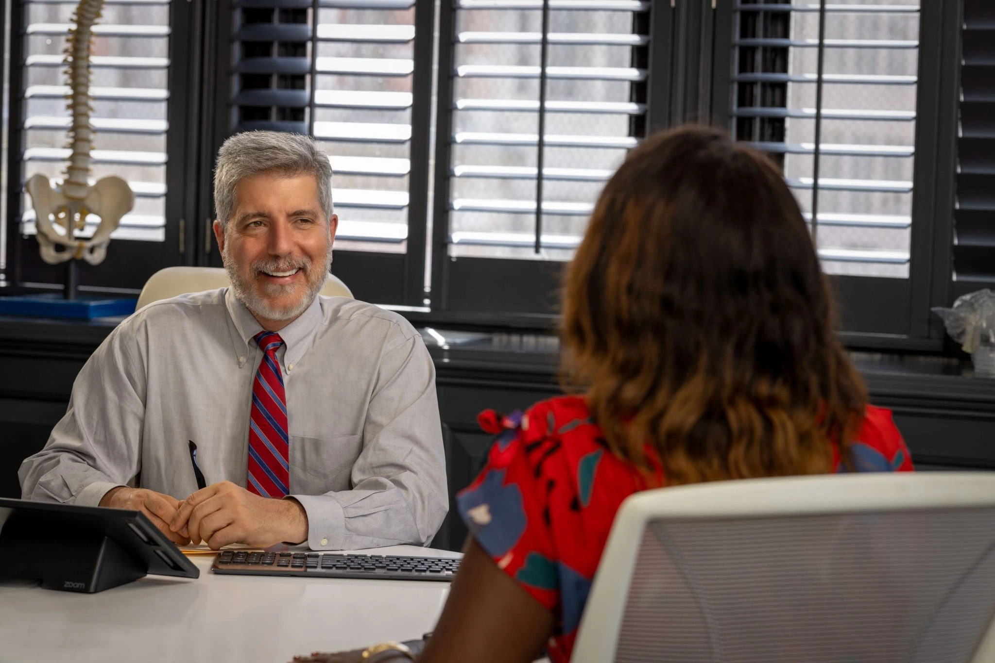 A doctor speaking with a patient in an office