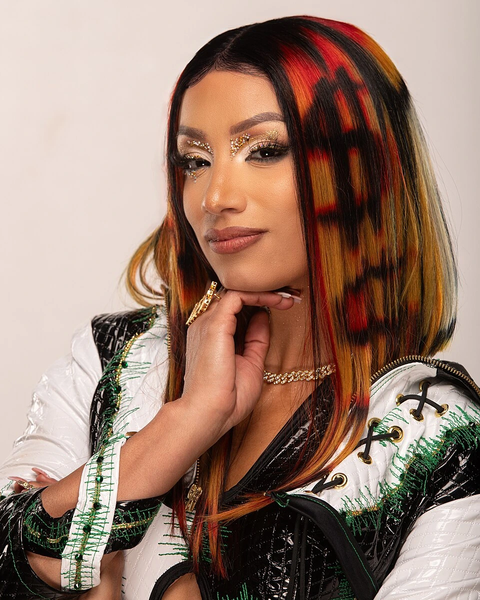 Mercedes Moné portrait photo in wrestling attire, posed against a plain background.