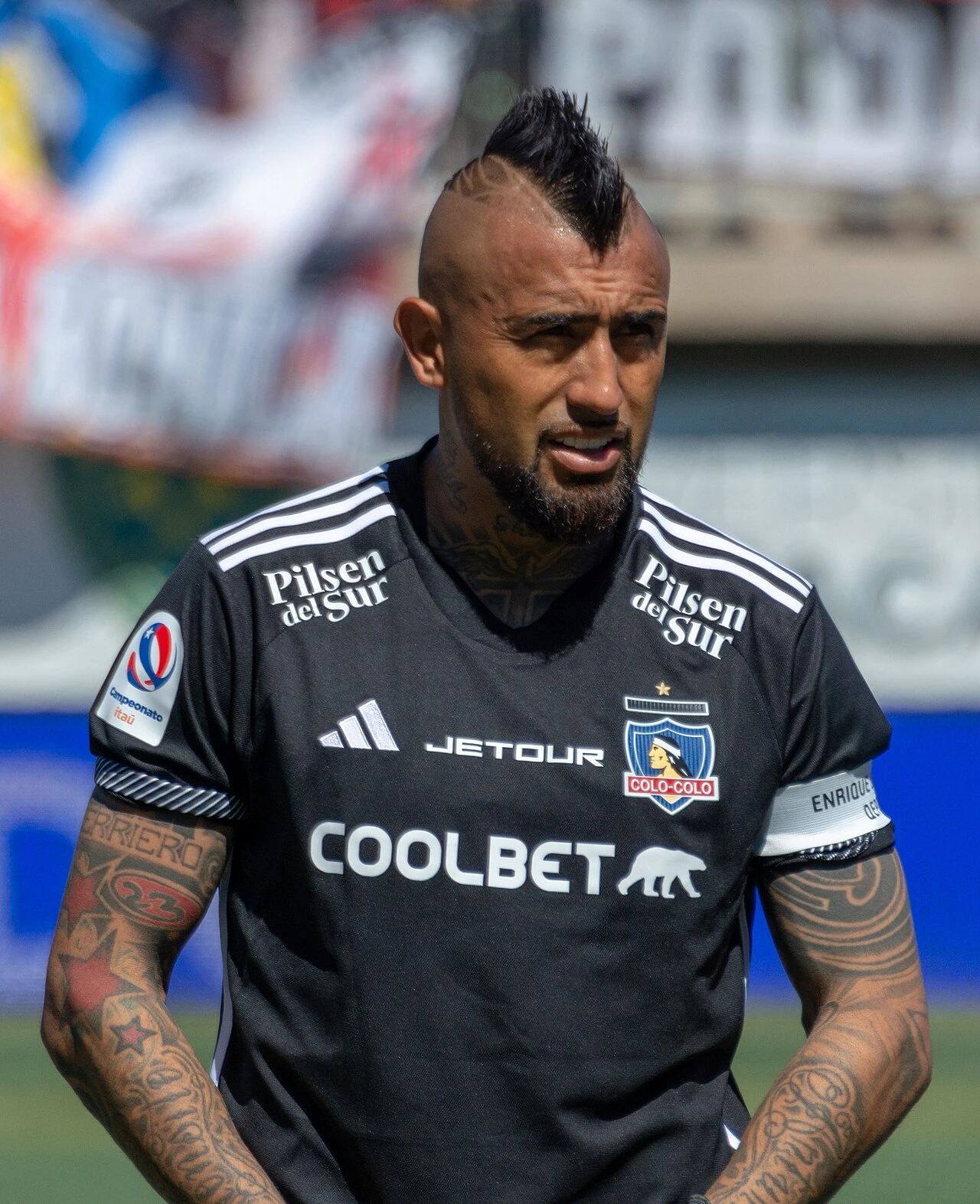 Arturo Vidal in a Colo-Colo kit during a match, standing on the pitch