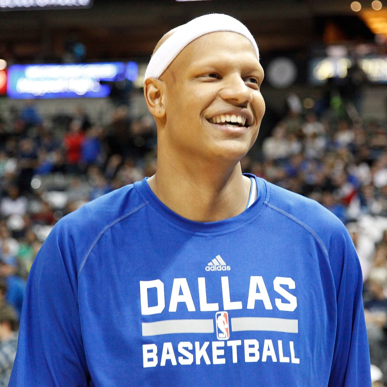 Charlie Villanueva in a Dallas Basketball warmup shirt, smiling in an arena