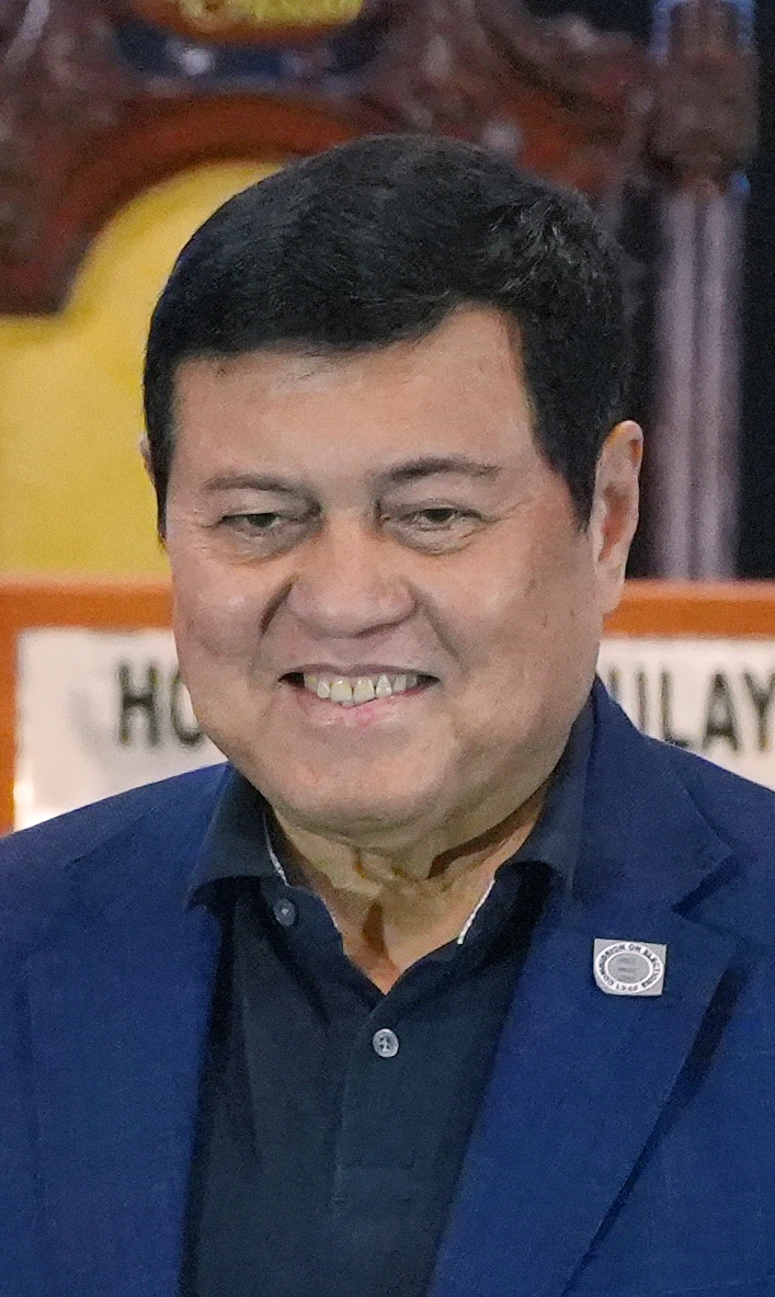 Manny Villar smiling in a blue jacket at an event