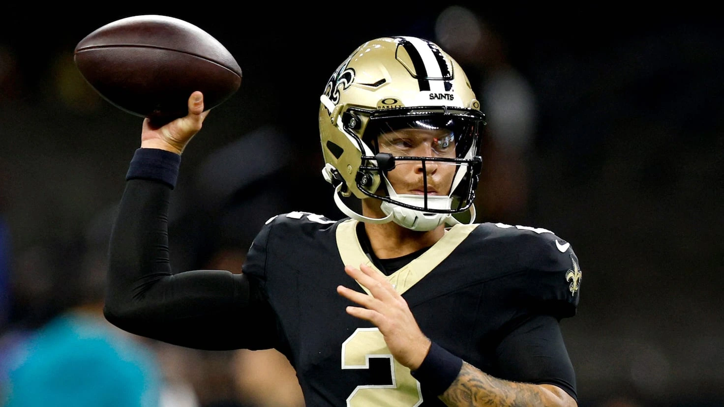 Spencer Rattler in a New Orleans Saints uniform preparing to throw a football