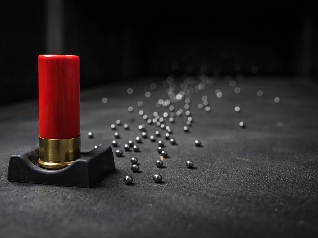 Macro photo of a 12-gauge shell on a test stand with a minimal pellet spread showing fewer distant pellets.