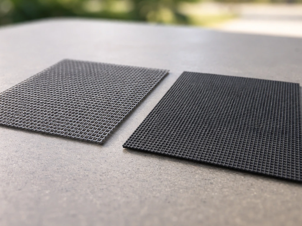 Closeup of two patio screen mesh samples showing loose fiberglass weave vs tighter solar/shade weave