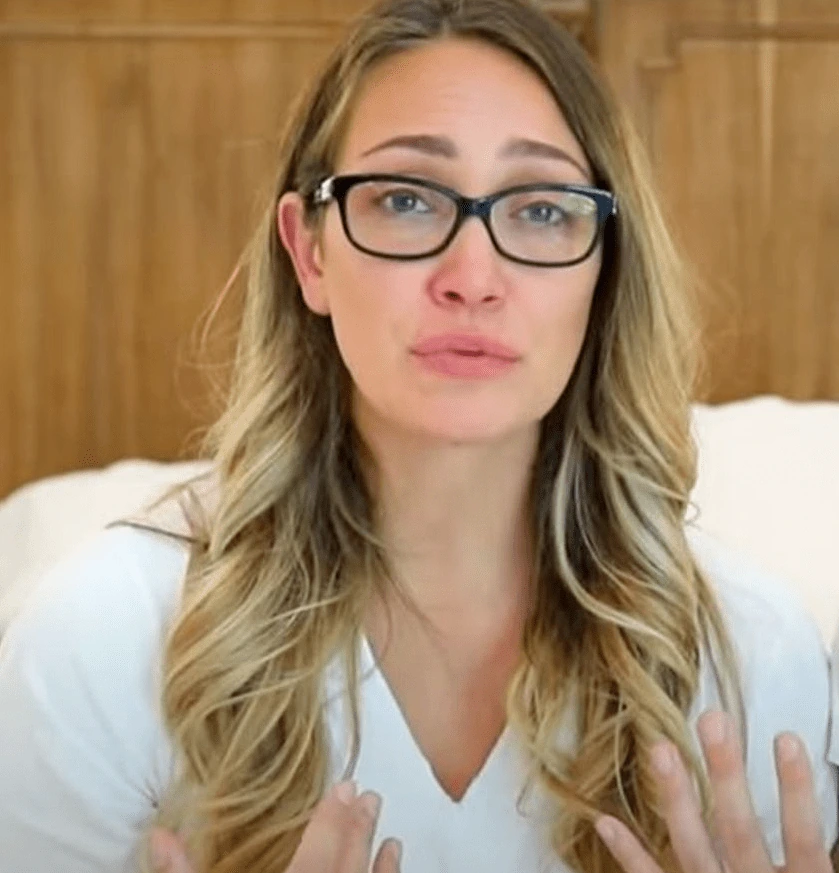 Portrait of Myka Stauffer speaking indoors, wearing glasses and a white top.