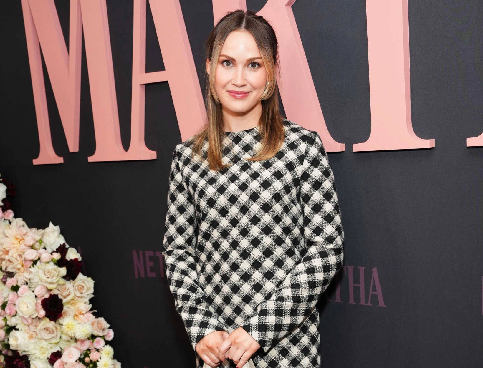 Meredith Hayden posing at an event in front of a branded backdrop