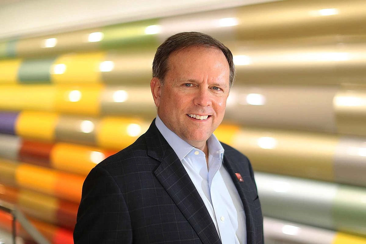 Portrait of Charles W. Shaver, Axalta Chairman and CEO, standing in a colorful interior setting.