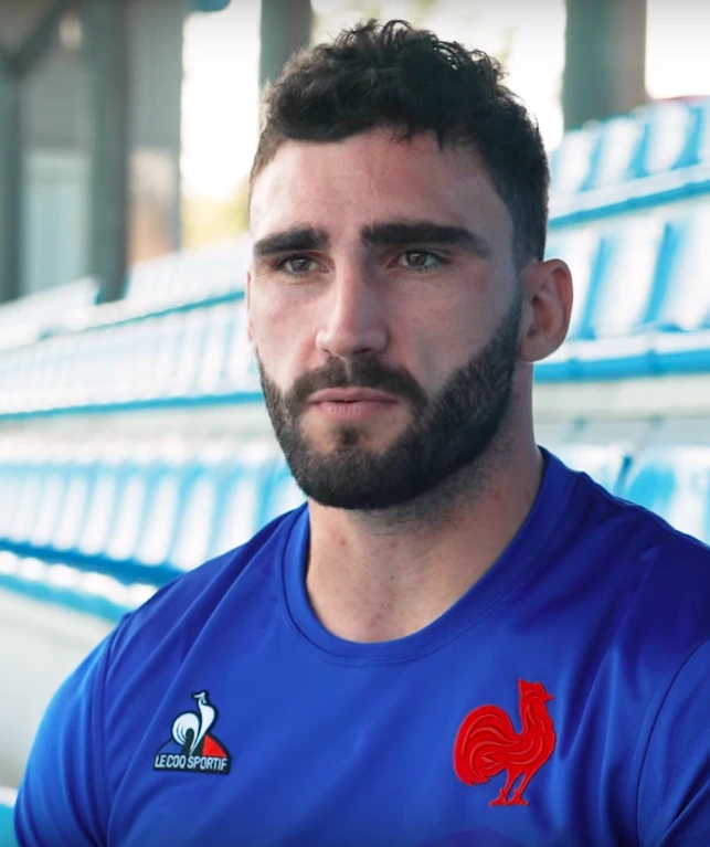 Charles Ollivon, French rugby union player, in a blue training shirt seated in a stadium