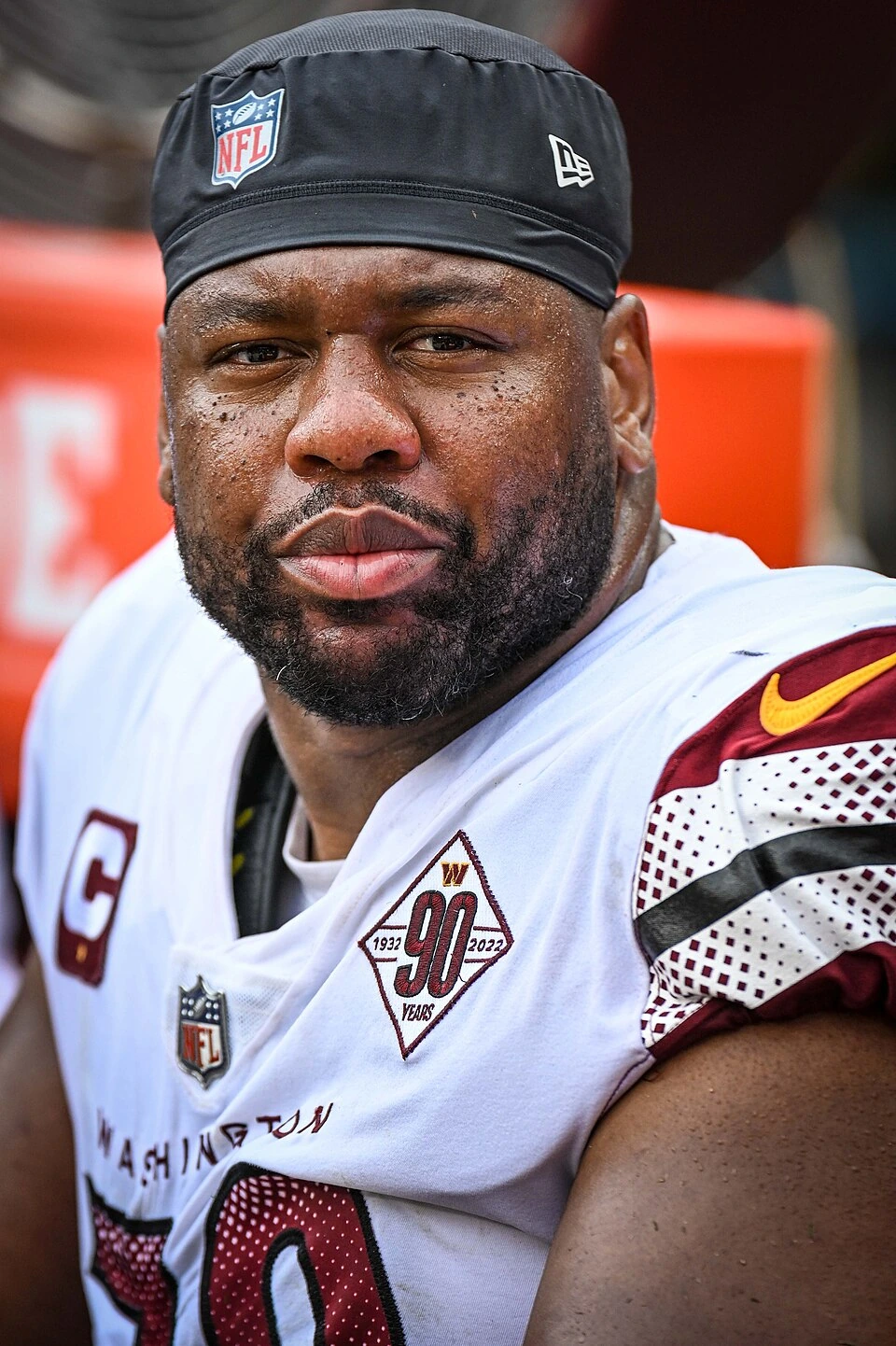 Charles Leno Jr. in a Washington Commanders uniform, seated on the bench during a game
