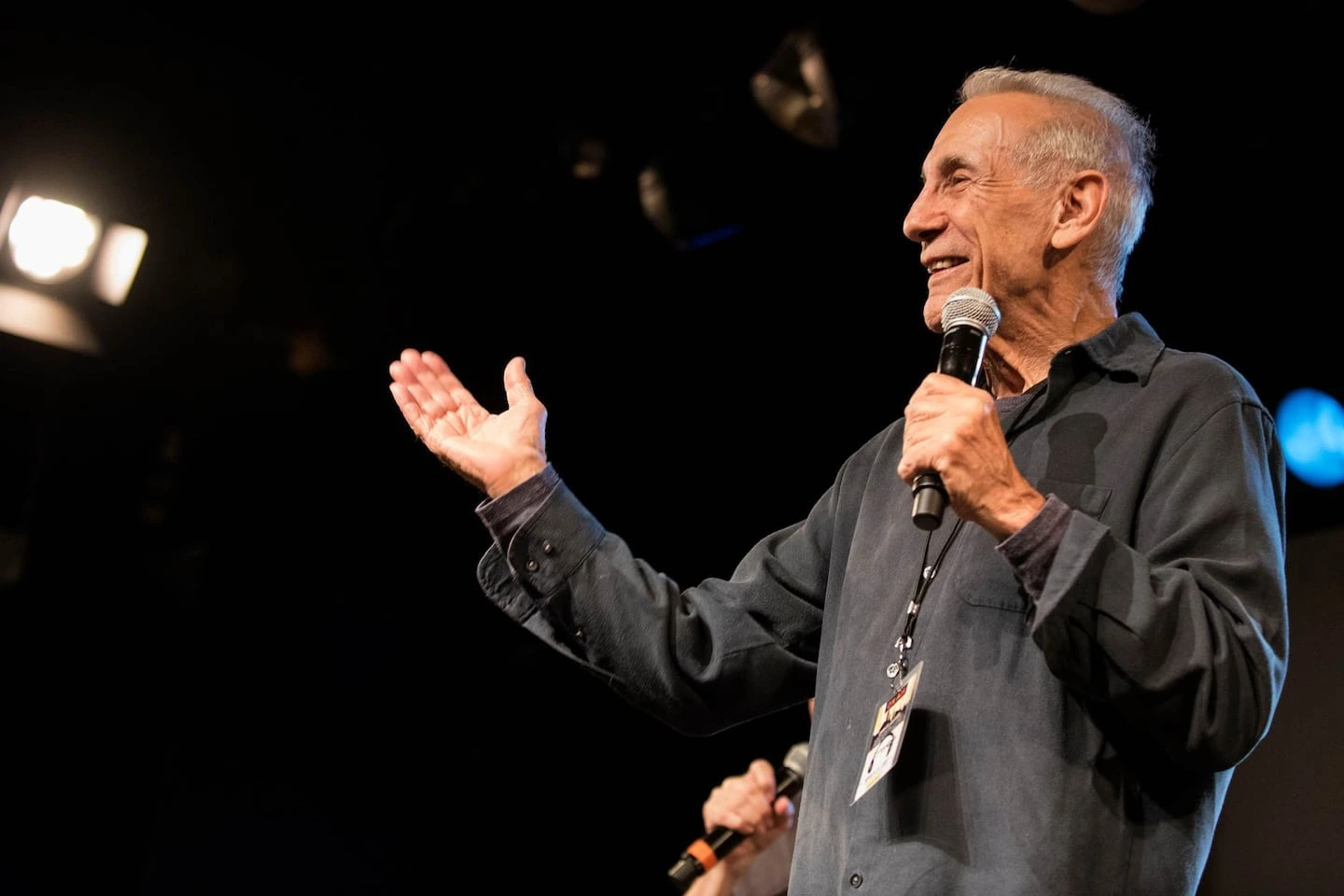 Charles Laquidara speaking on stage with a microphone